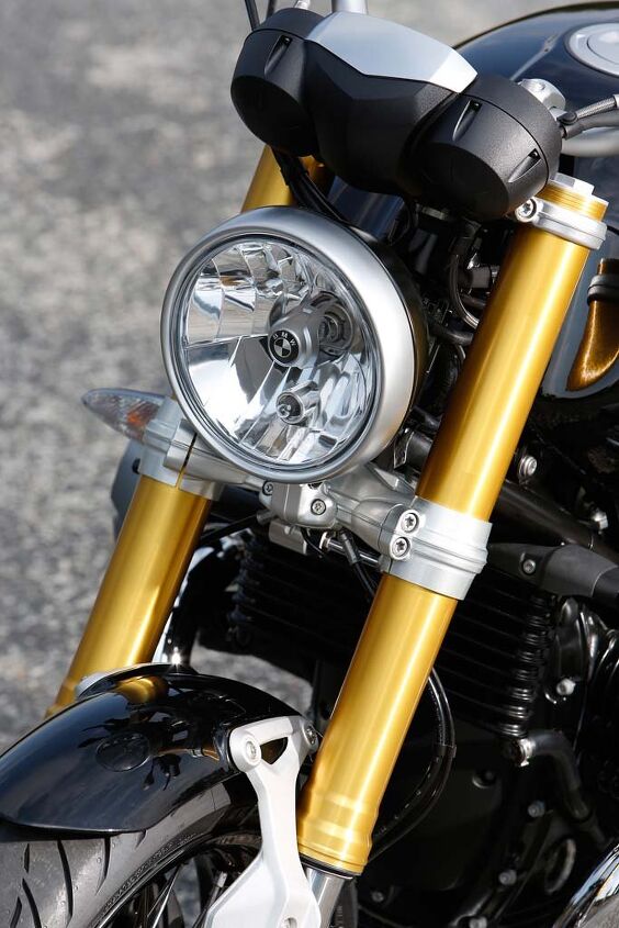 A study in contrasts: Modern gold fork, retro-styled fender strut, and a classic round headlight with a high-tech reflector.