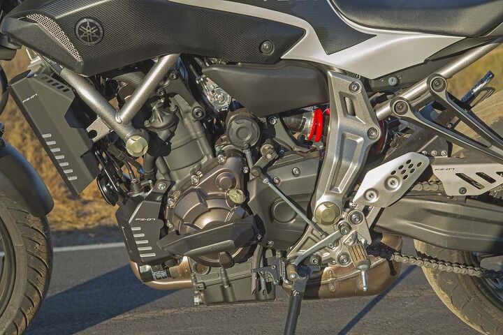 Under those aluminum bronze plugs from the GYT-R accessory catalog, the FZ’s front engine mounts ride in plastic bushings that allow a little lateral movement; so do the steel “ears” that bolt to the back of the cylinder head. Cheap but MotoGP-effective ...