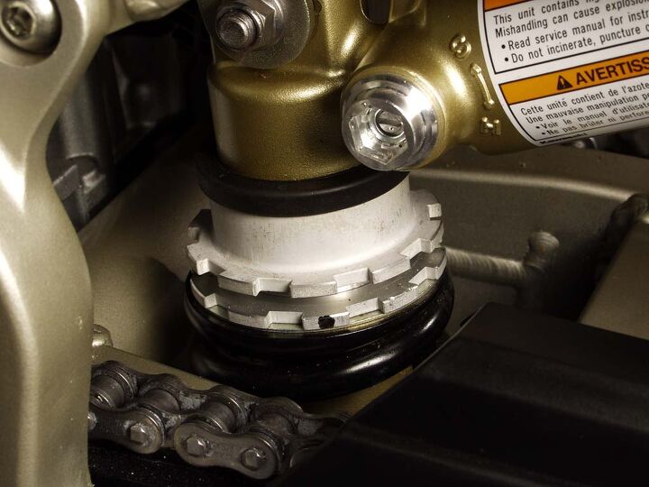 Here’s a monoshock and its locking-ring spring preload adjuster. The shiny bit in the upper middle of the photo is the compression-damping adjusting screw. Note the S (soft) and H (hard) markings. Photo by Evans Brasfield.
