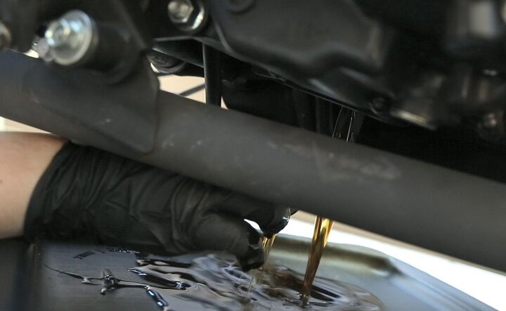 Used motor oil contains known carcinogens. Wear protective gloves. Also, make sure your arm is in a position that prevents hot oil from running down it as it pours out of the engine.