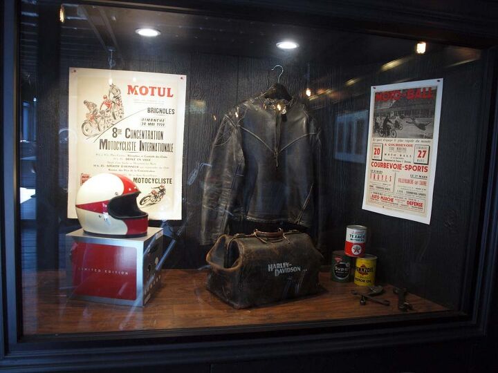 Interior window display features original gear and posters from French motorcycling events including the 1930 Motorcycle Soccer competitions. 