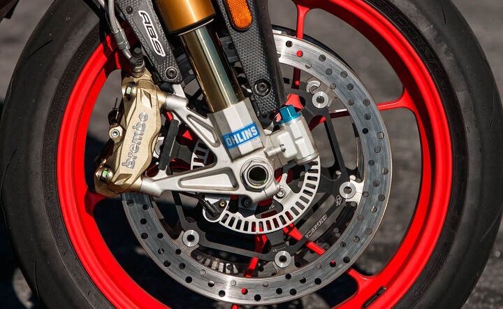 The majority of changes between the Tuono V4 1100 RR and Factory summed up in one photo. The Factory gets Öhlins suspension and steering damper, aluminum front brake rotor flanges, wider 200/55-17 rear tire, and red wheels.