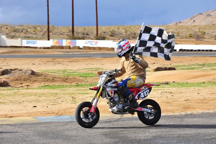 Robert Perez taking the a lap of honor with the checkered flag and the race-winning machine.