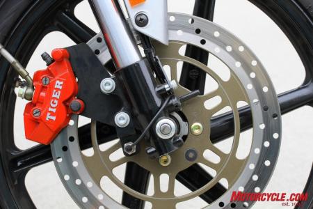 Twin-pot front calipers work with a 290mm rotor for decent whoa-power. Note speedo-sensor pickup on rotor in line with mounting bolts.