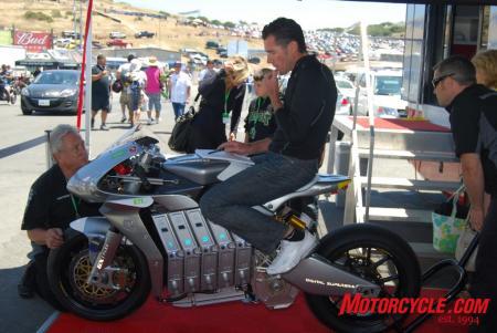 Michael Czysz takes notes while sitting aboard his remarkably attractive E1pc electric-powered motorcycle. Czysz would take the win in the FIM e-Power electric motorcycle race with a last-seconds pass on Michael Barnes whose bike simply ran out of power yards from the finish.