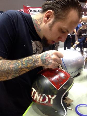 Skratch, of Skratch’s Garage, inks a special “Indy” open face in the Bell booth. Occasionally Bell will convert Skratch’s hand-drawn custom designs into production helmet color schemes.
