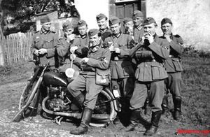 Team of cycle soldiers with the tell-tale round signal sign indicating traffic control, one of the many duties assigned the motorized infantry.