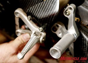 OEM foot pegs are replaced by aftermarket rearsets. These Woodcraft rearsets featured a round knurled peg, for positive traction in various body positions, and is non-folding to add protection in case of a crash. (Photo by Holly Marcus)