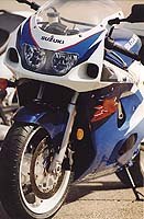 Four-piston calipers and a conventional fork are fitted. The GSX-R750 uses upside-down forks and six-piston brakes, costing about $1300 more.